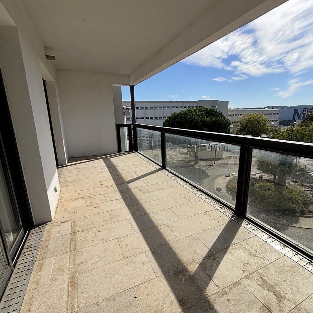 La même terrasse vidée : sol en pierre dégagé, garde-corps vitré, vue dégagée.